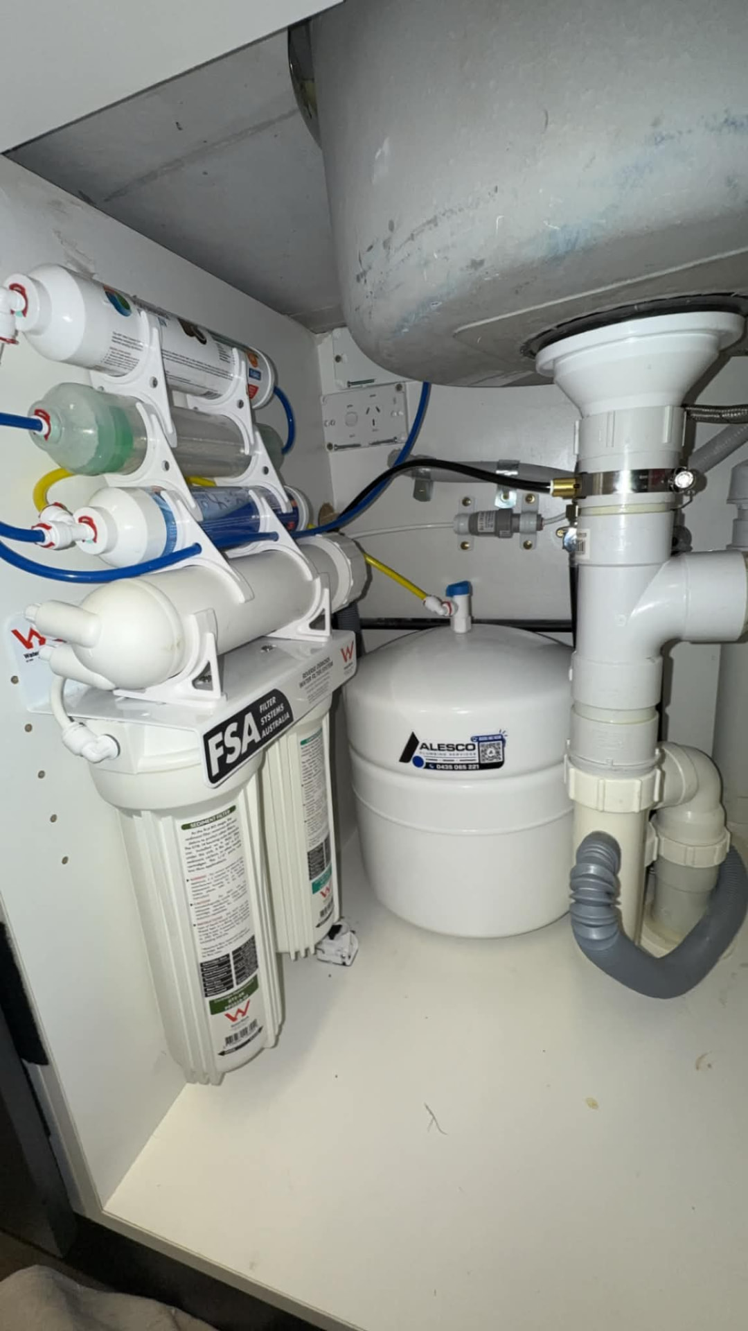 Undersink reverse osmosis filtration system installed under a kitchen sink by Alesco