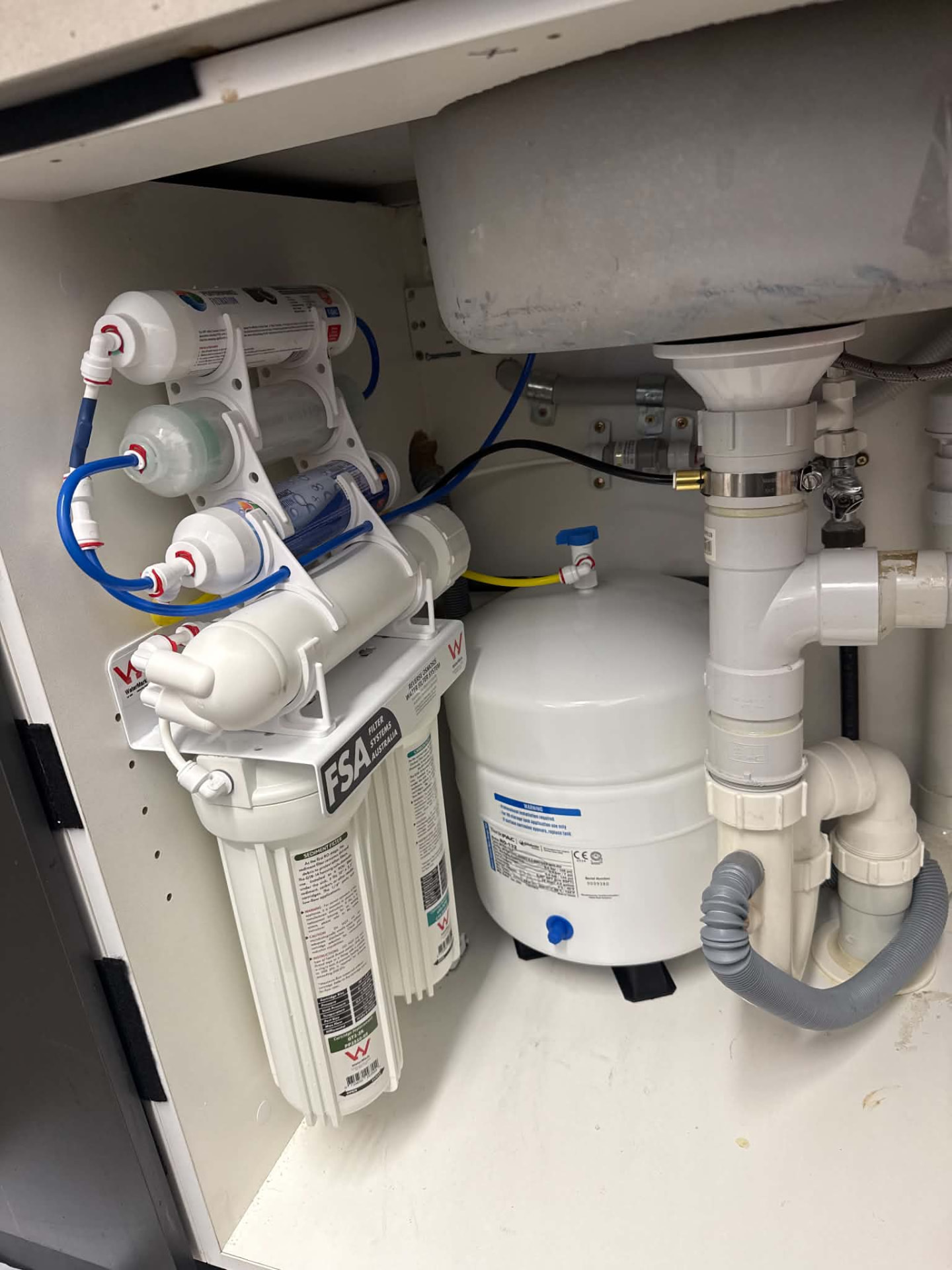 Undersink reverse osmosis filtration system installed under a kitchen sink by Alesco